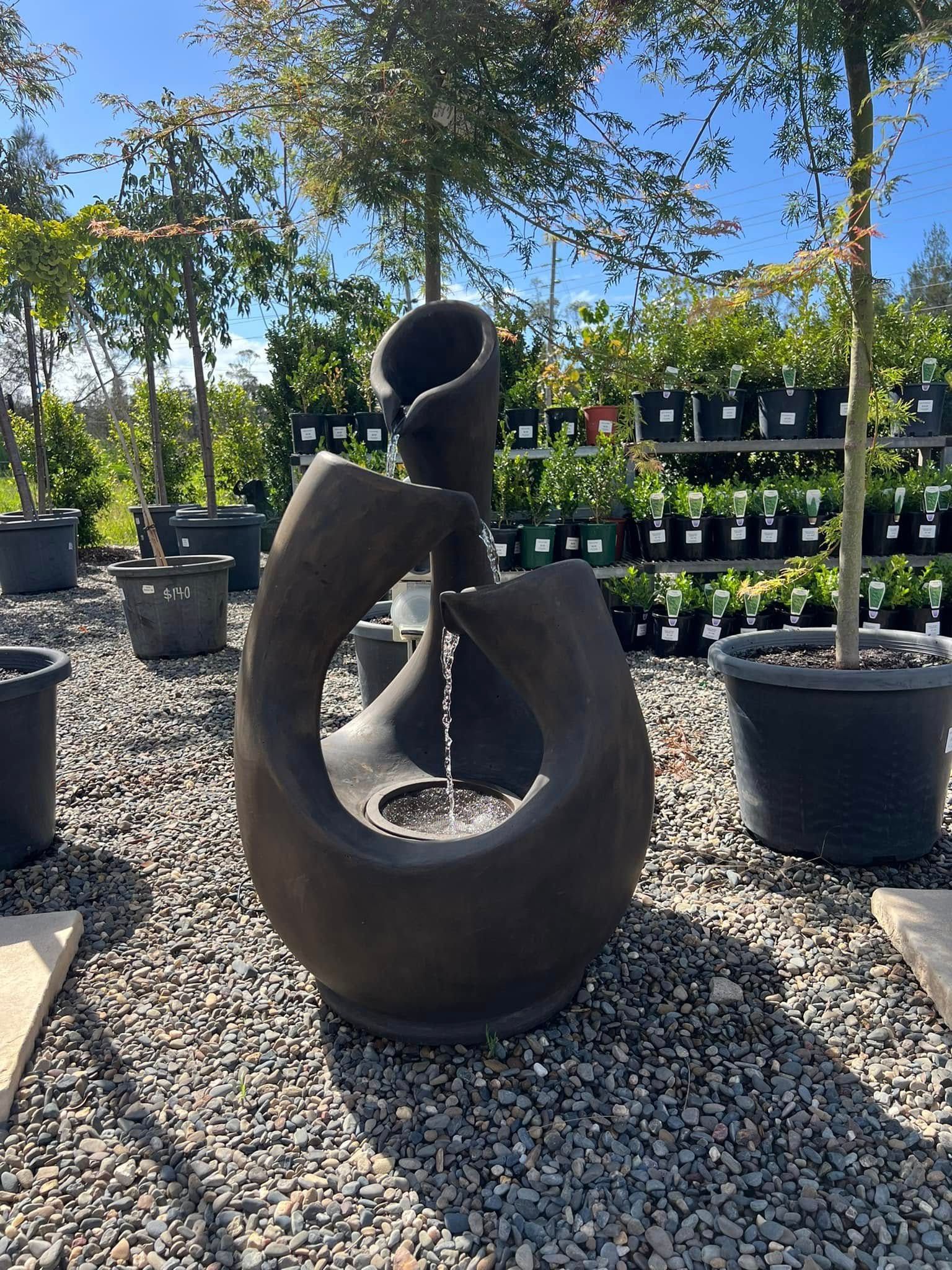 Water Fountain in A Garden Center, Made of Dark Stone, with Water Flowing — Port Landscape Supplies in Port Macquarie, NSW