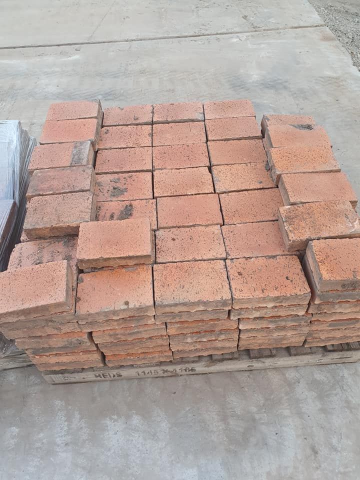 Stack of Red-Brown Rectangular Bricks on A Wooden Pallet, Outdoors — Port Landscape Supplies in Port Macquarie, NSW