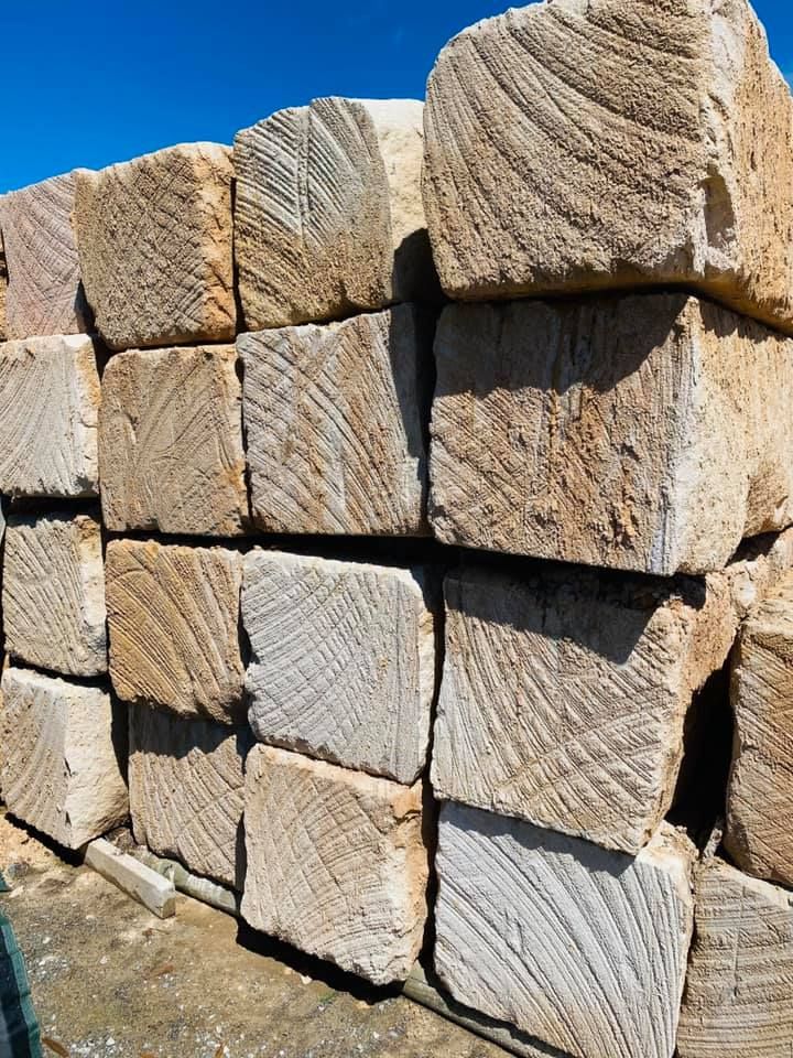 Pile Of Square Light-Brown Sandstone Blocks With Textured Surfaces — Port Landscape Supplies in Port Macquarie, NSW