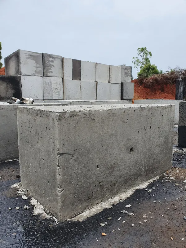 Concrete Rectangular Blocks Stacked Outdoors on a Wet Surface, Overcast Sky — Port Landscape Supplies in Port Macquarie, NSW