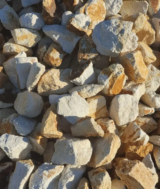 Pile of rough tan and gray rocks stacked in sunlight