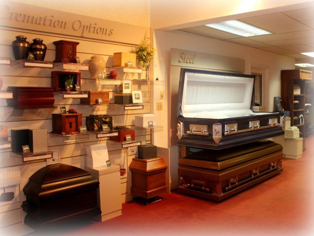 Funeral home showroom with cremation urns and coffins on display.