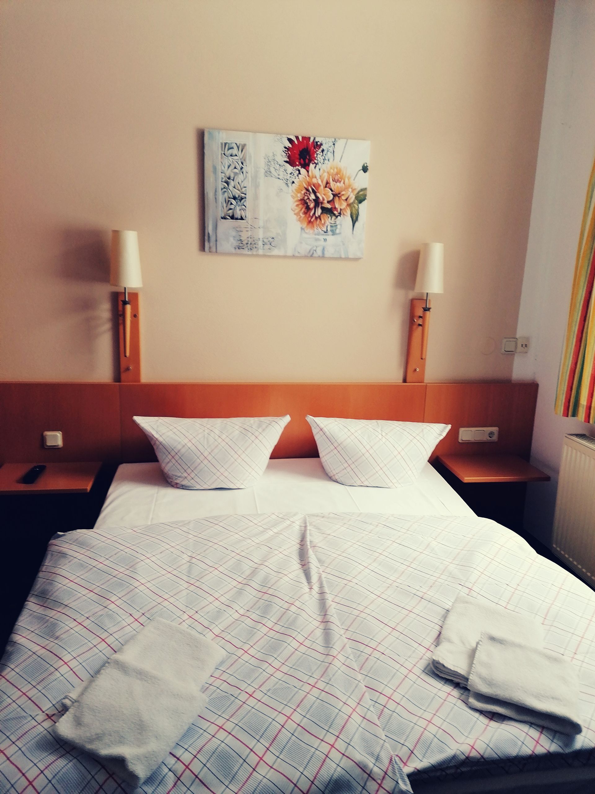 A bedroom with a bed and a painting on the wall above it