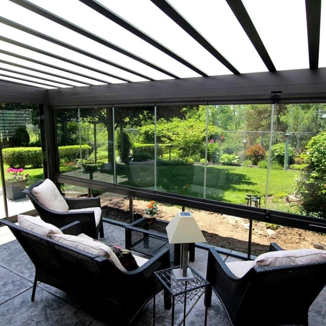 Patio coperto con sedie in vimini che si affaccia su un rigoglioso giardino verde.