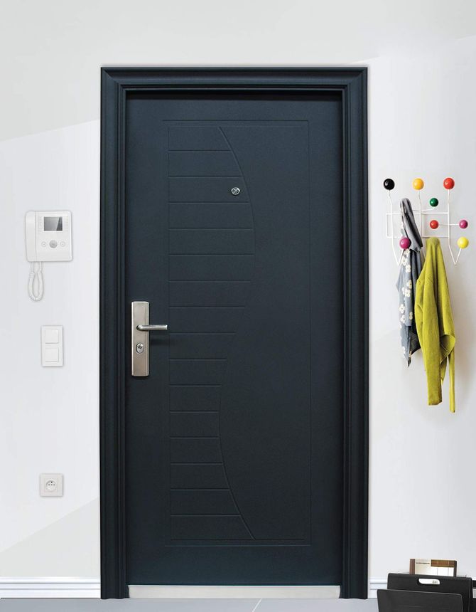 Porta d'ingresso scura con maniglia argentata, ganci a muro con una giacca gialla e le chiavi, in un ingresso bianco