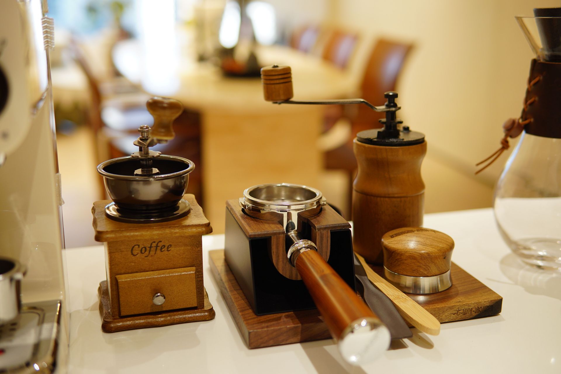 Vintage coffee grinders and brewing tools on a warmly lit counter — illustrative photo