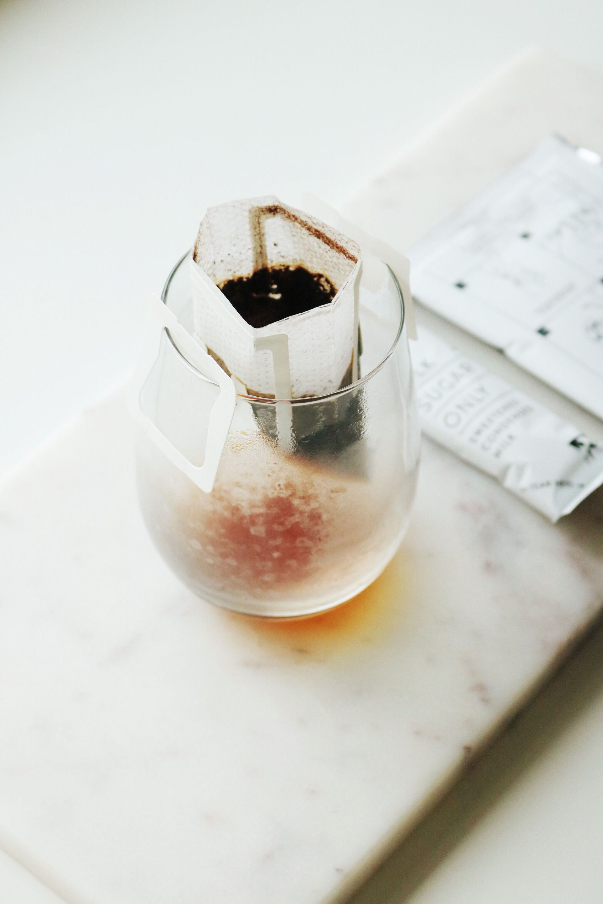 Glass pour-over coffee brewer on a pale counter — illustrative photo