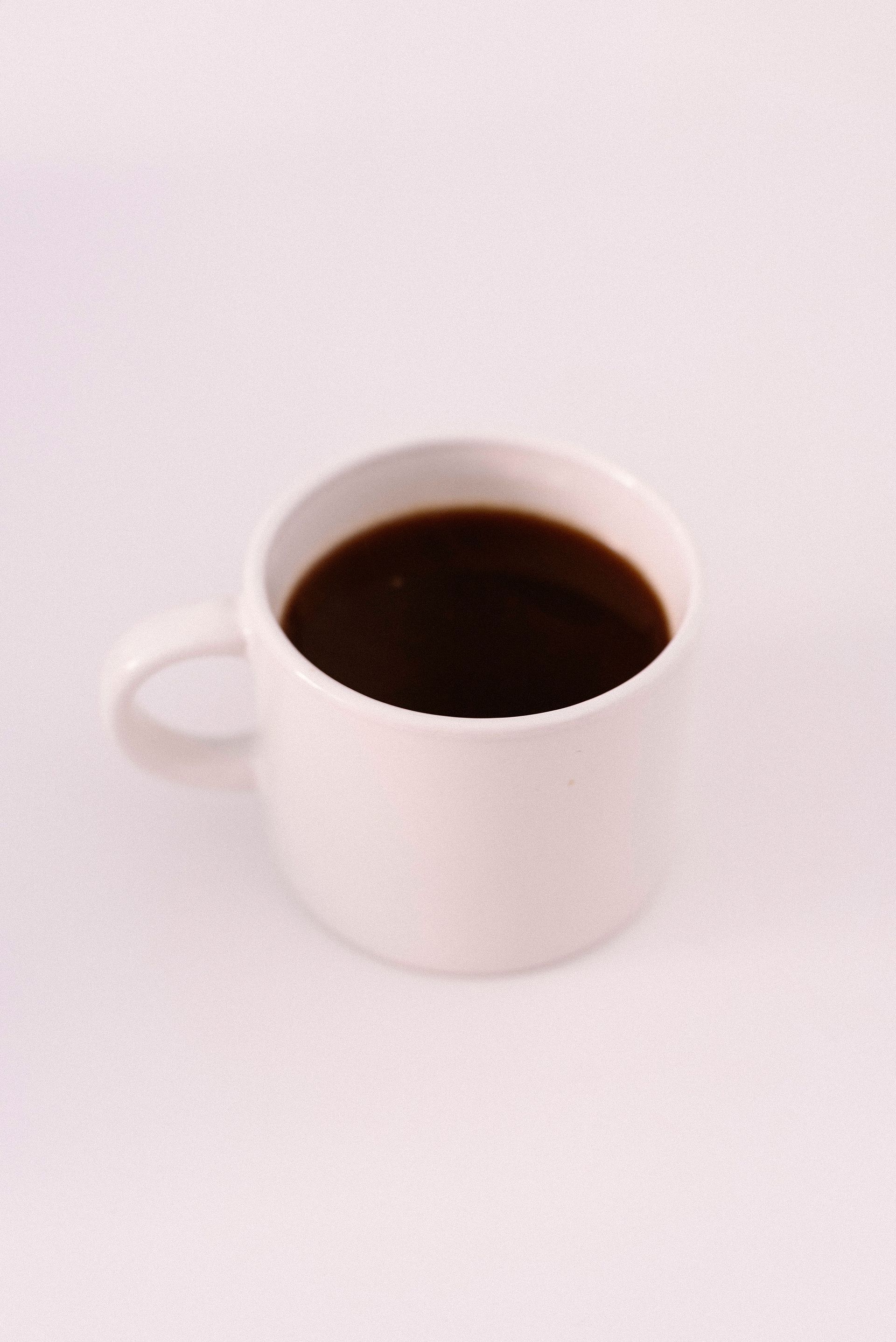 Plain mug of black coffee on a pale surface — illustrative prepared coffee photo