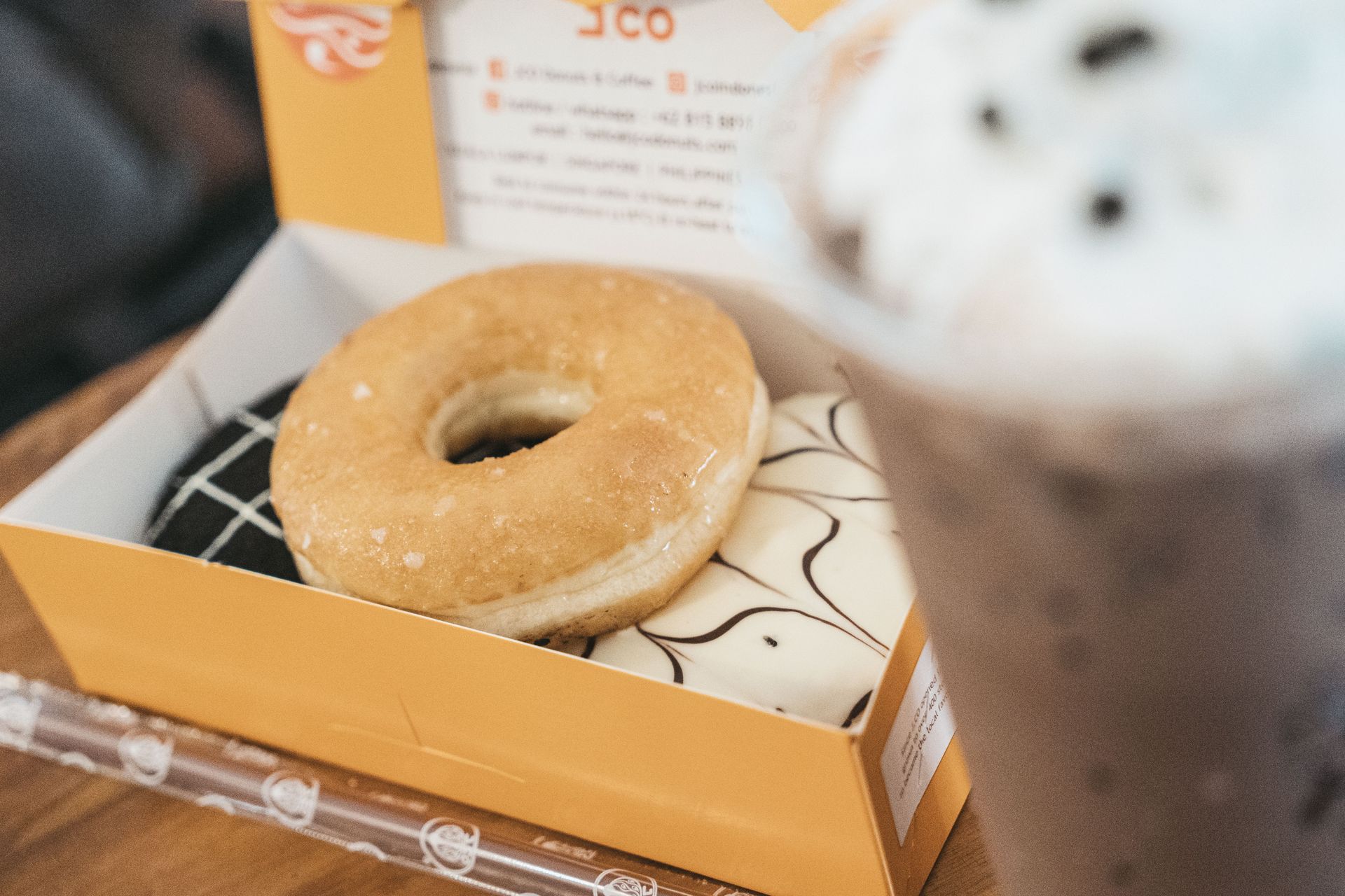 Ring donut beside a white coffee cup — illustrative coffee pairing; donut not included