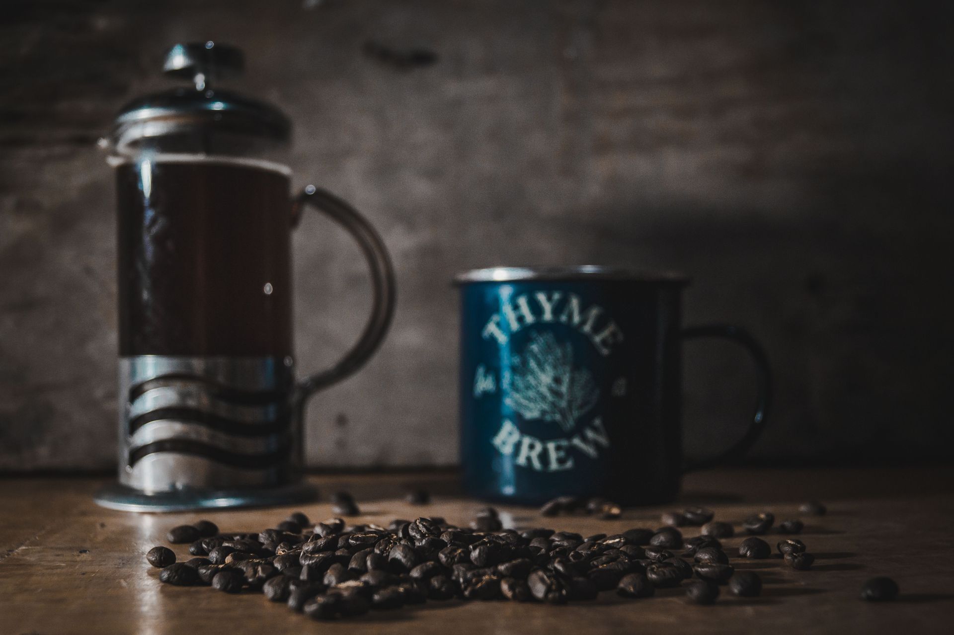 French press and dark blue coffee mug on a rustic table — illustrative photo