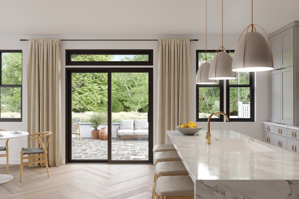 A kitchen with a large island and sliding glass doors leading to a patio.