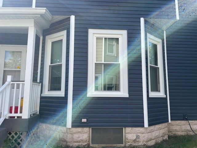 Blue house exterior with white trim around windows.