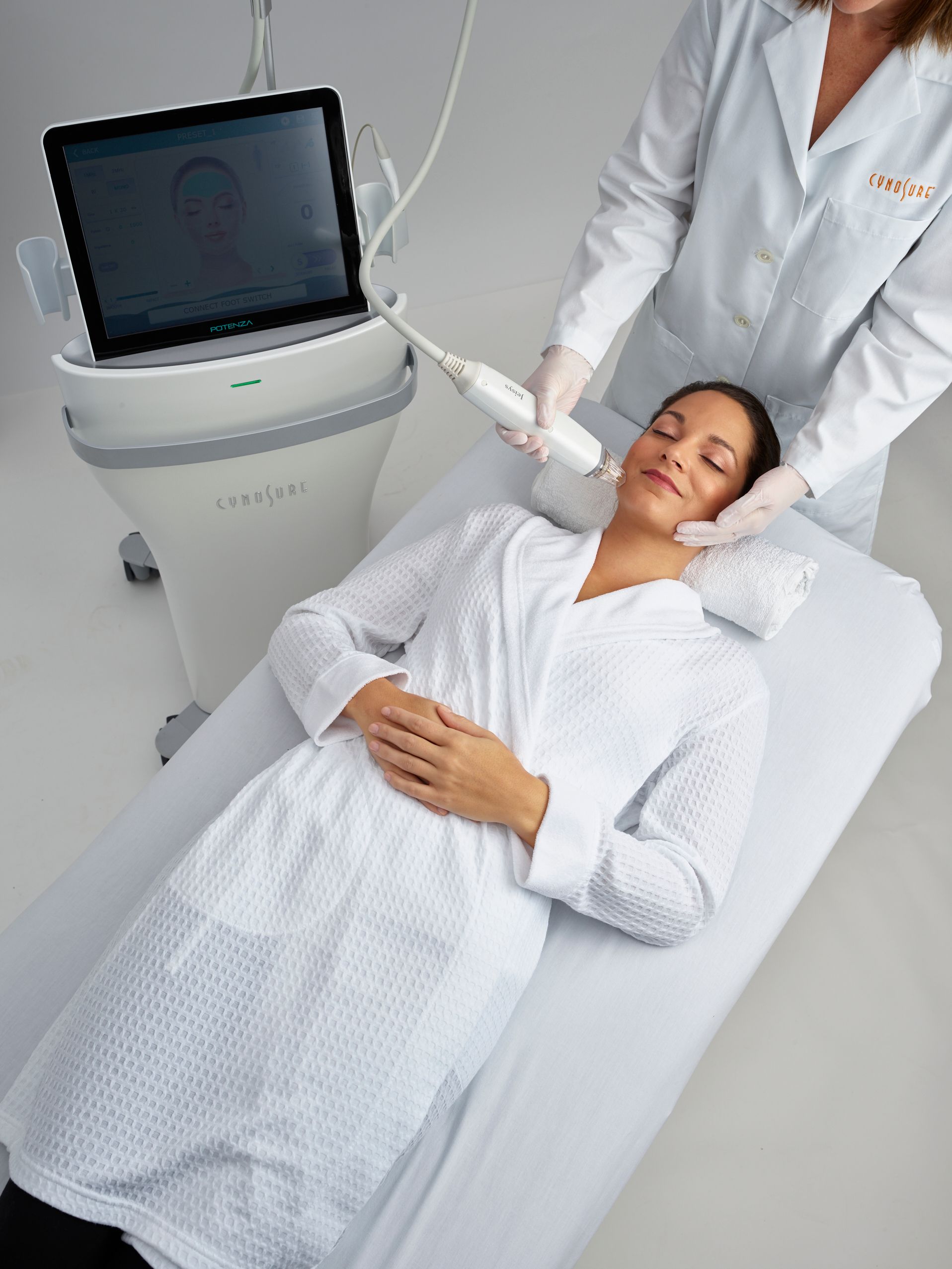 A woman is laying on a bed getting a treatment from a doctor
