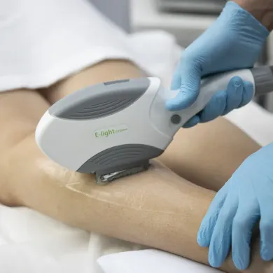 A woman is getting a laser treatment on her leg