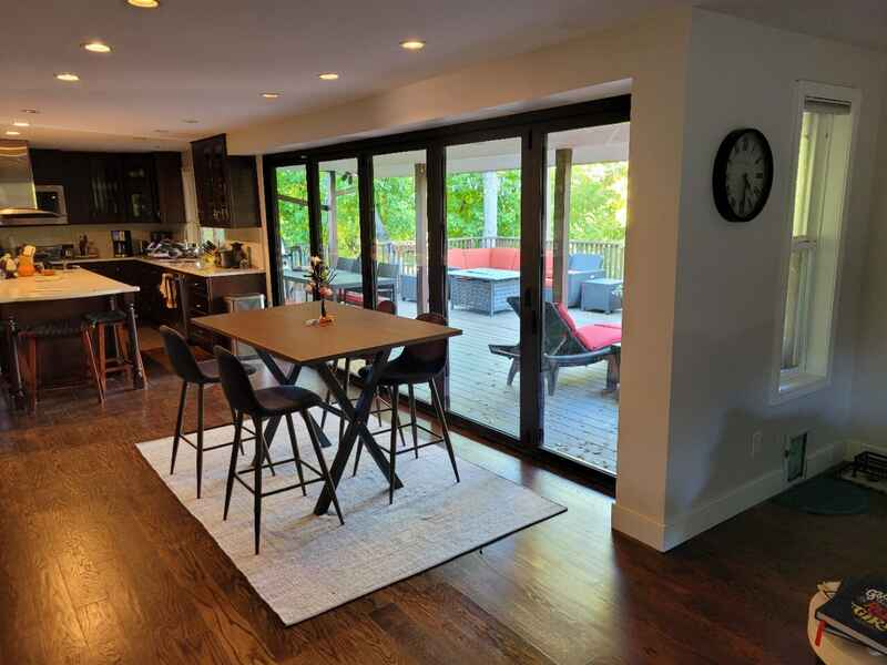 Interior kitchen with table and chairs facing sliding doors to an outdoor patio with furniture.