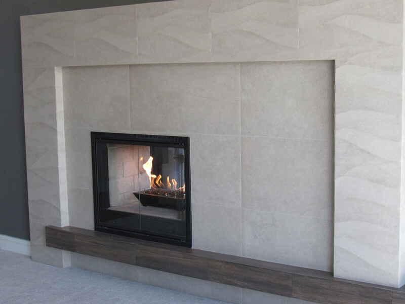 Fireplace with beige tile surround, dark fireplace insert with flames, and a wooden hearth.