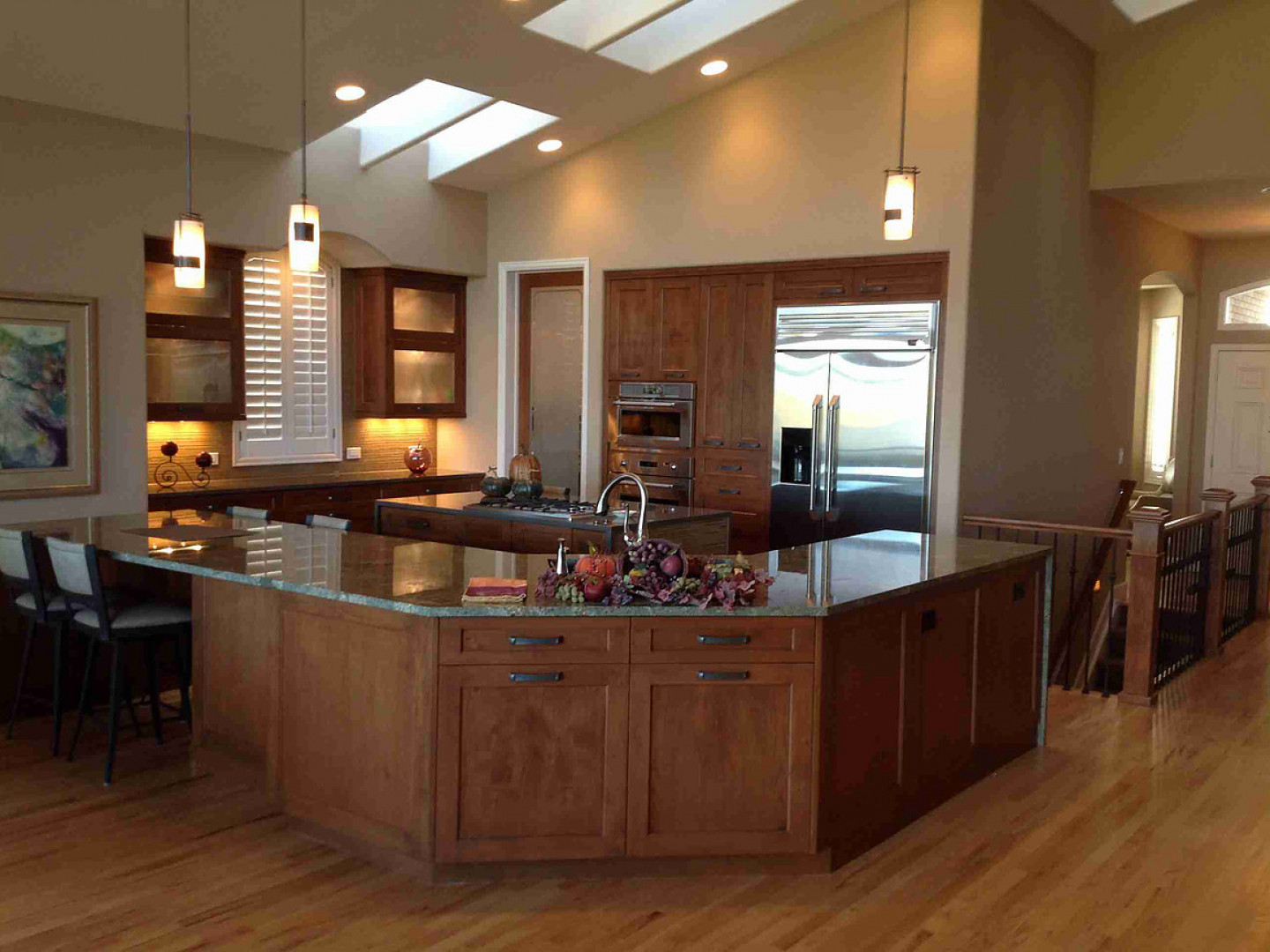 Spacious kitchen with a large island, wooden cabinets, granite countertops, and a view to the outdoors.