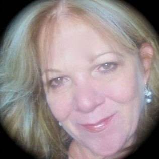 Woman with blonde hair and earrings, smiling.