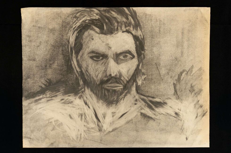 Charcoal portrait of a man with beard and focused expression.