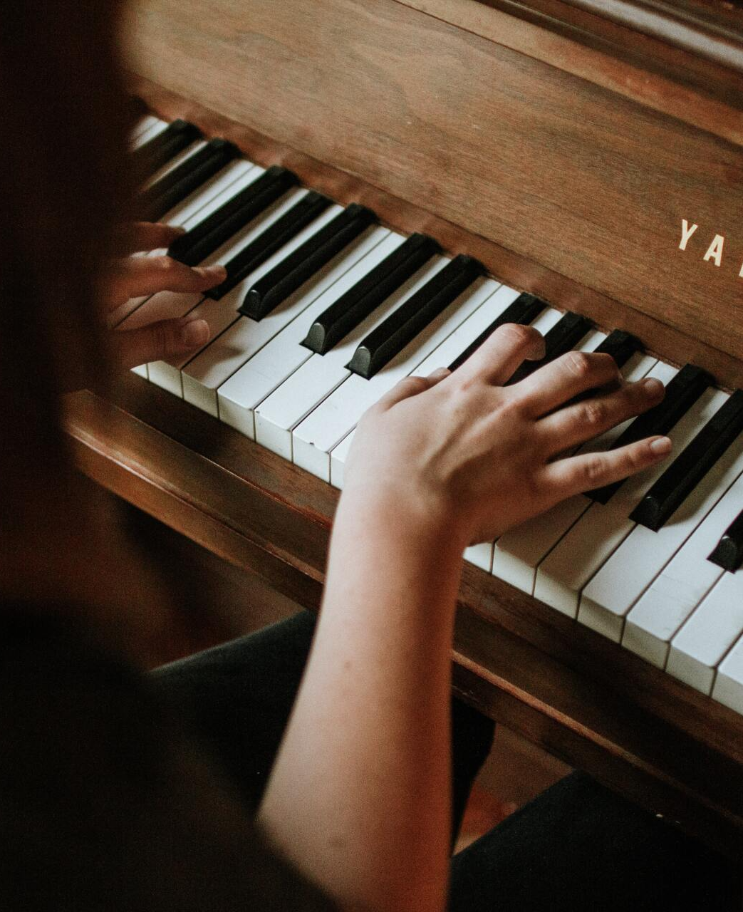 Person playing the piano, representative of Christian worship