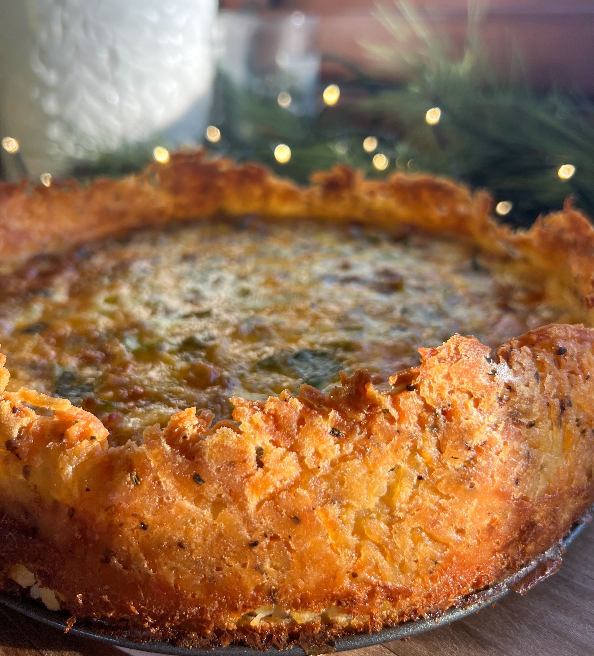 A close up of a quiche on a plate on a table.