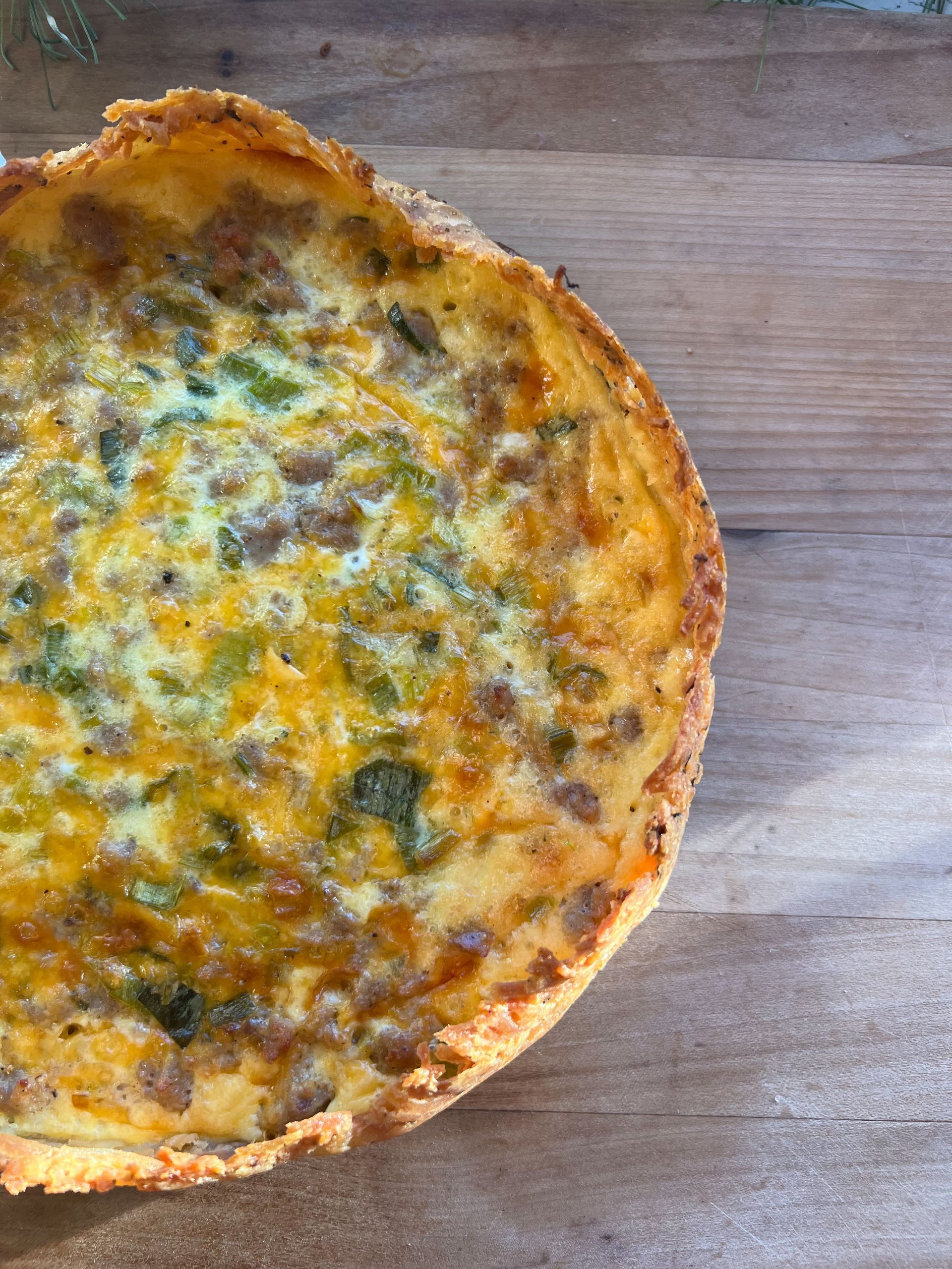 A pizza is sitting on a wooden table.