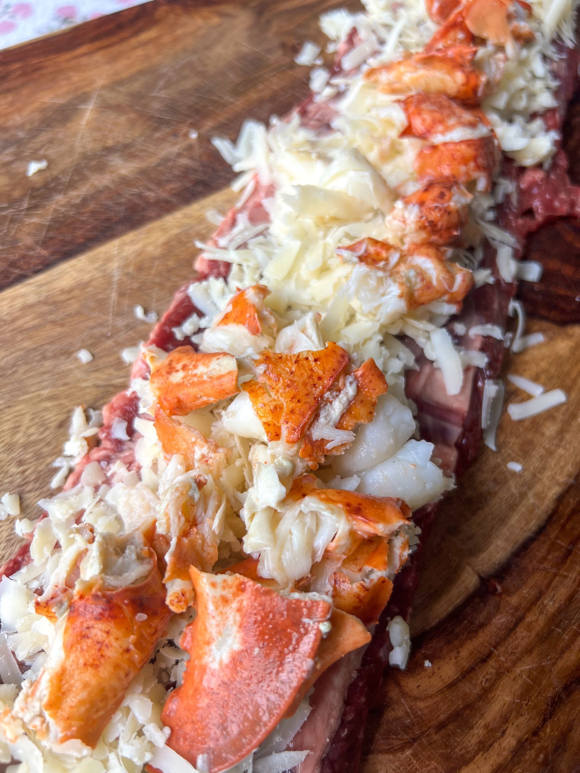 A close up of a piece of food on a wooden cutting board.