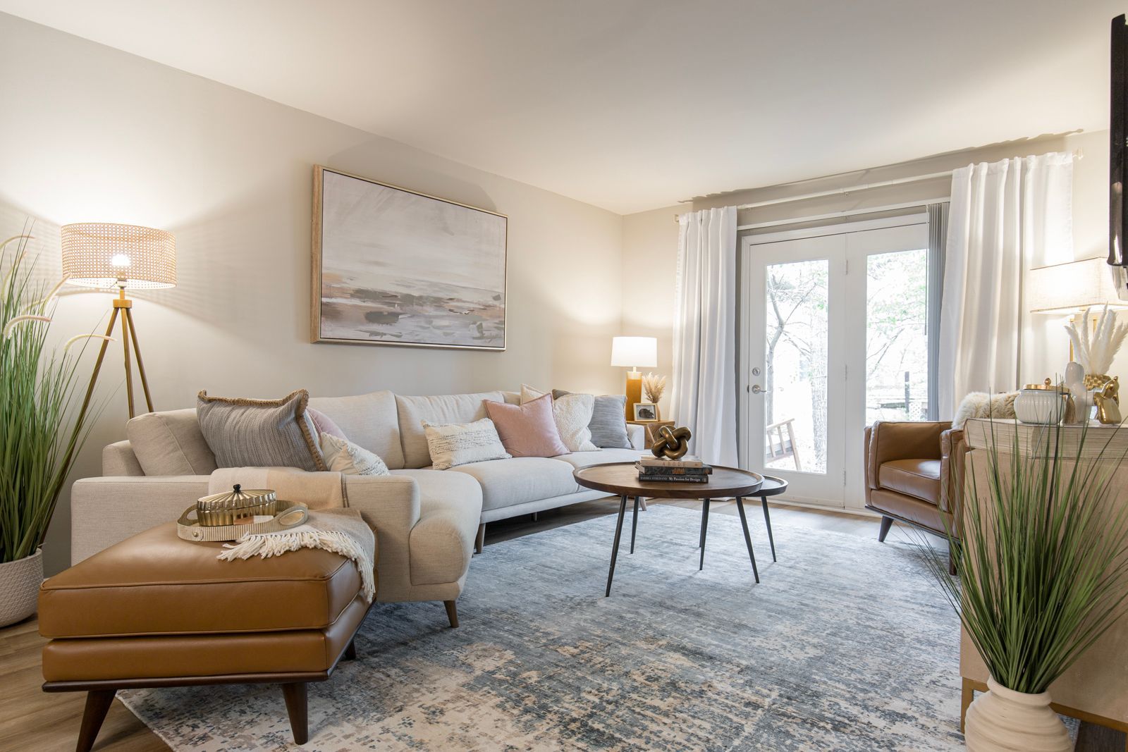 A living room with a couch , chair , coffee table and ottoman.