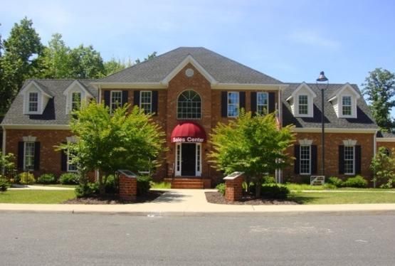 A large brick house with a red awning over the front door