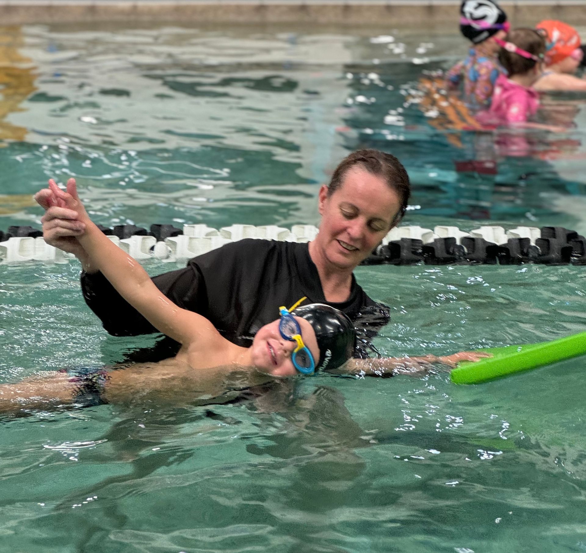 child swimming with instructor