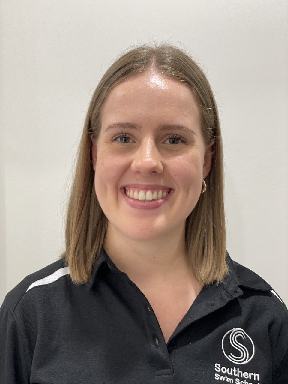 A woman in a black shirt is smiling for the camera.