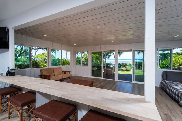 Interior space with bar, sofas, and large windows overlooking a waterfront view.