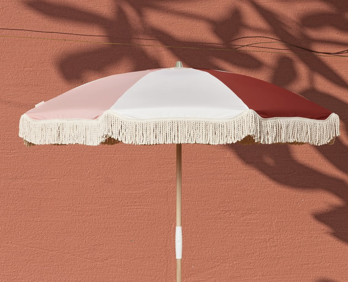 Auf einer roten Fläche steht ein rot-weißer Regenschirm von Courant Sauvage.