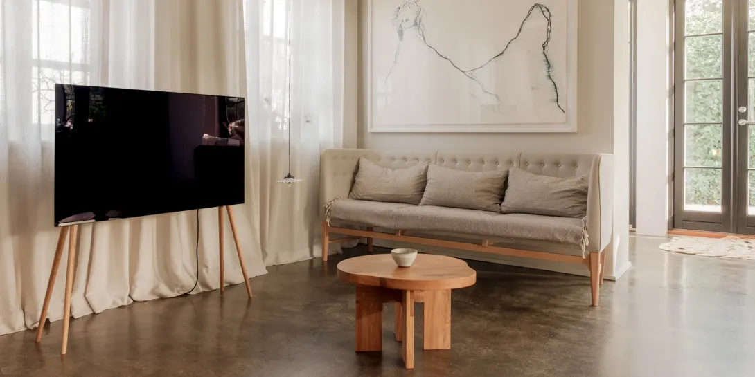 Ein Wohnzimmer mit Couch, Tisch und Fernseher.