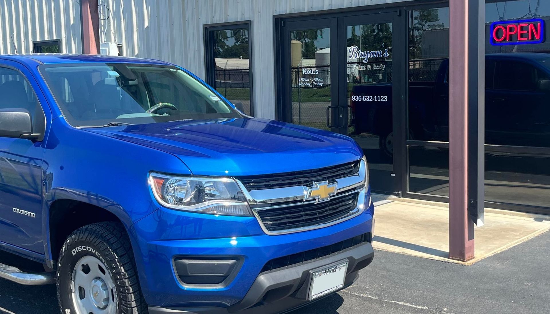 Blue Chevrolet truck parked in front of a building with an 