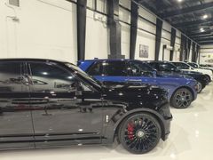 A black mercedes benz g class is parked in a dark parking lot.