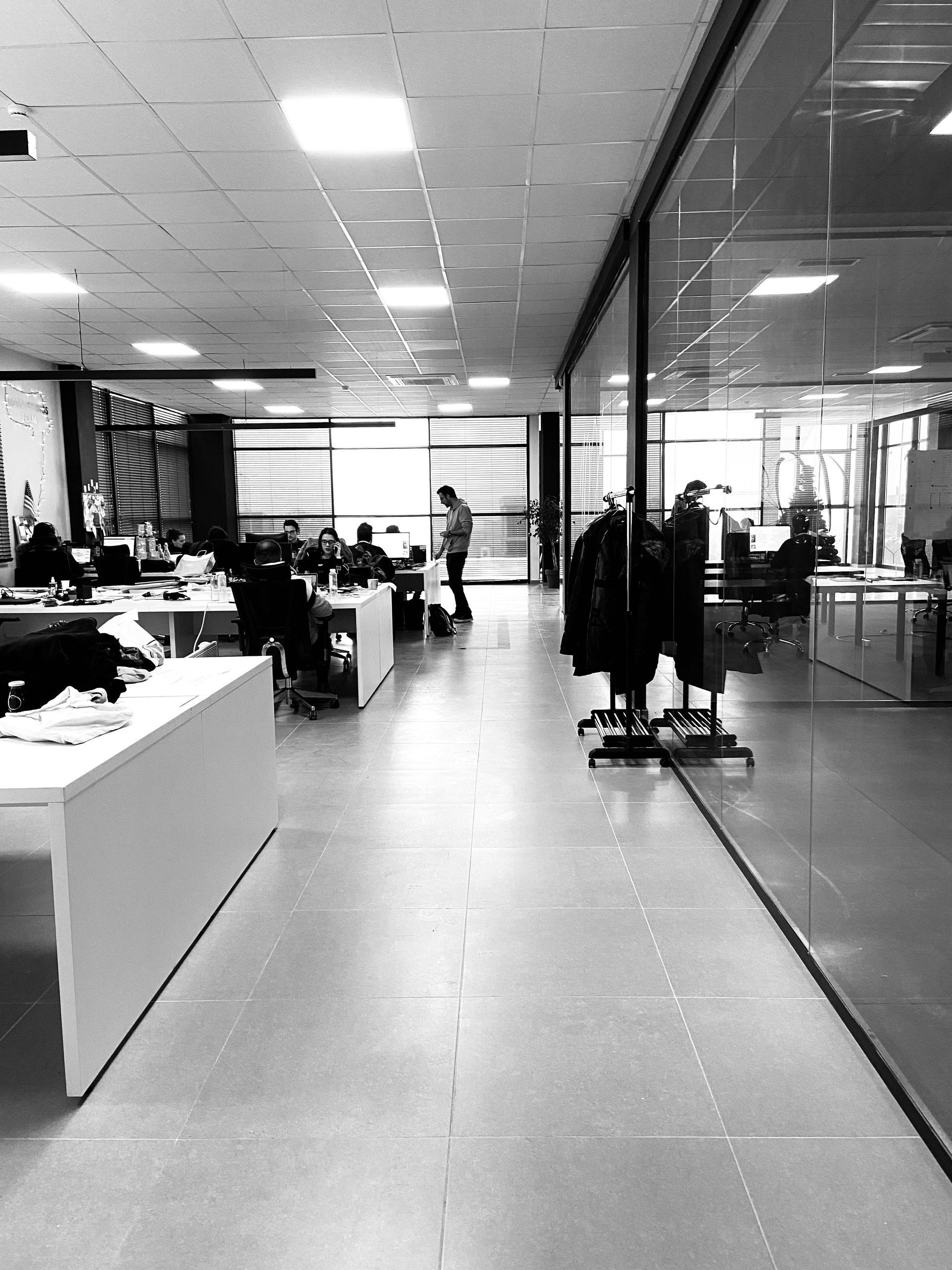 A black and white photo of a large office with people sitting at desks