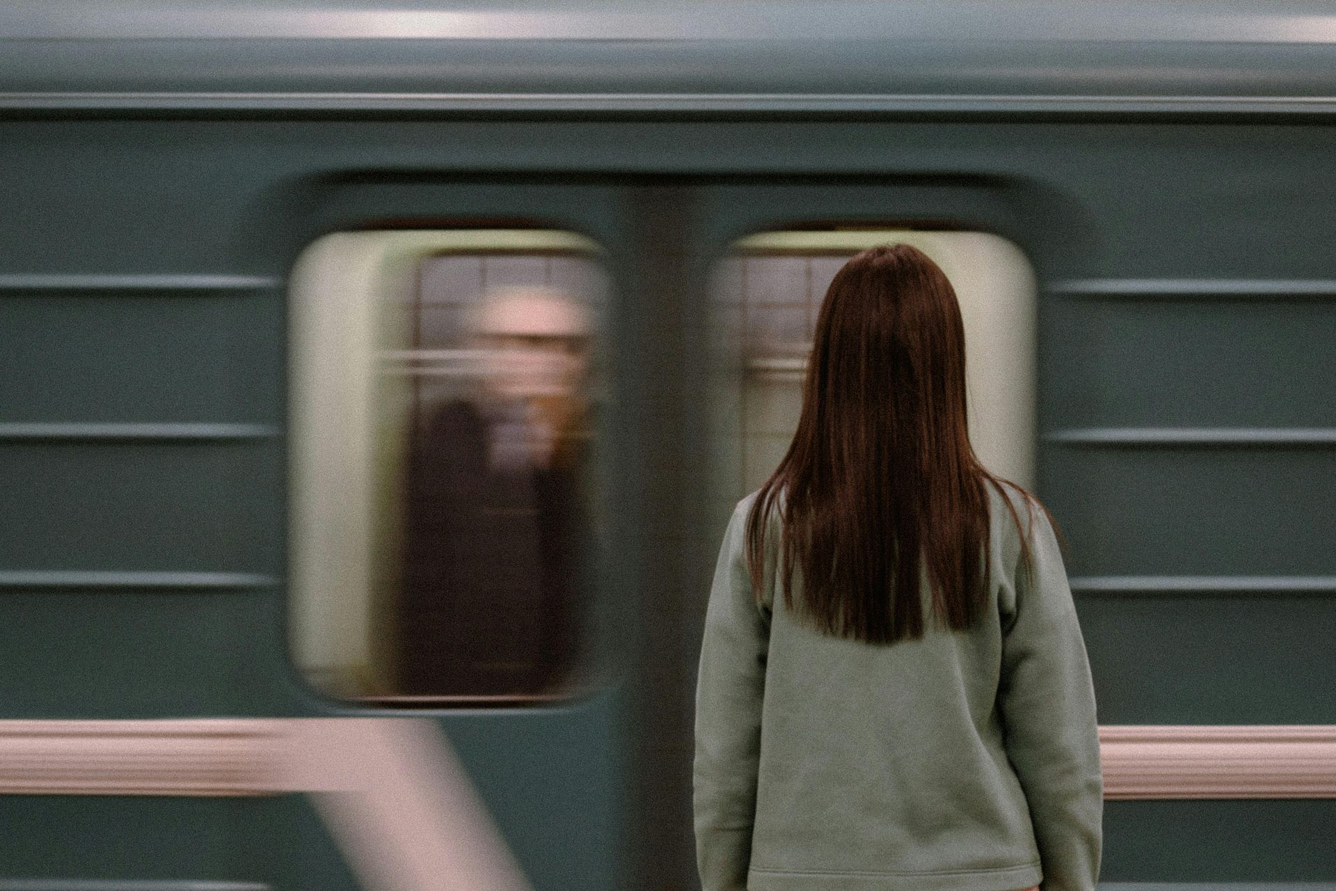 Escolhas A woman is standing in front of a subway train.