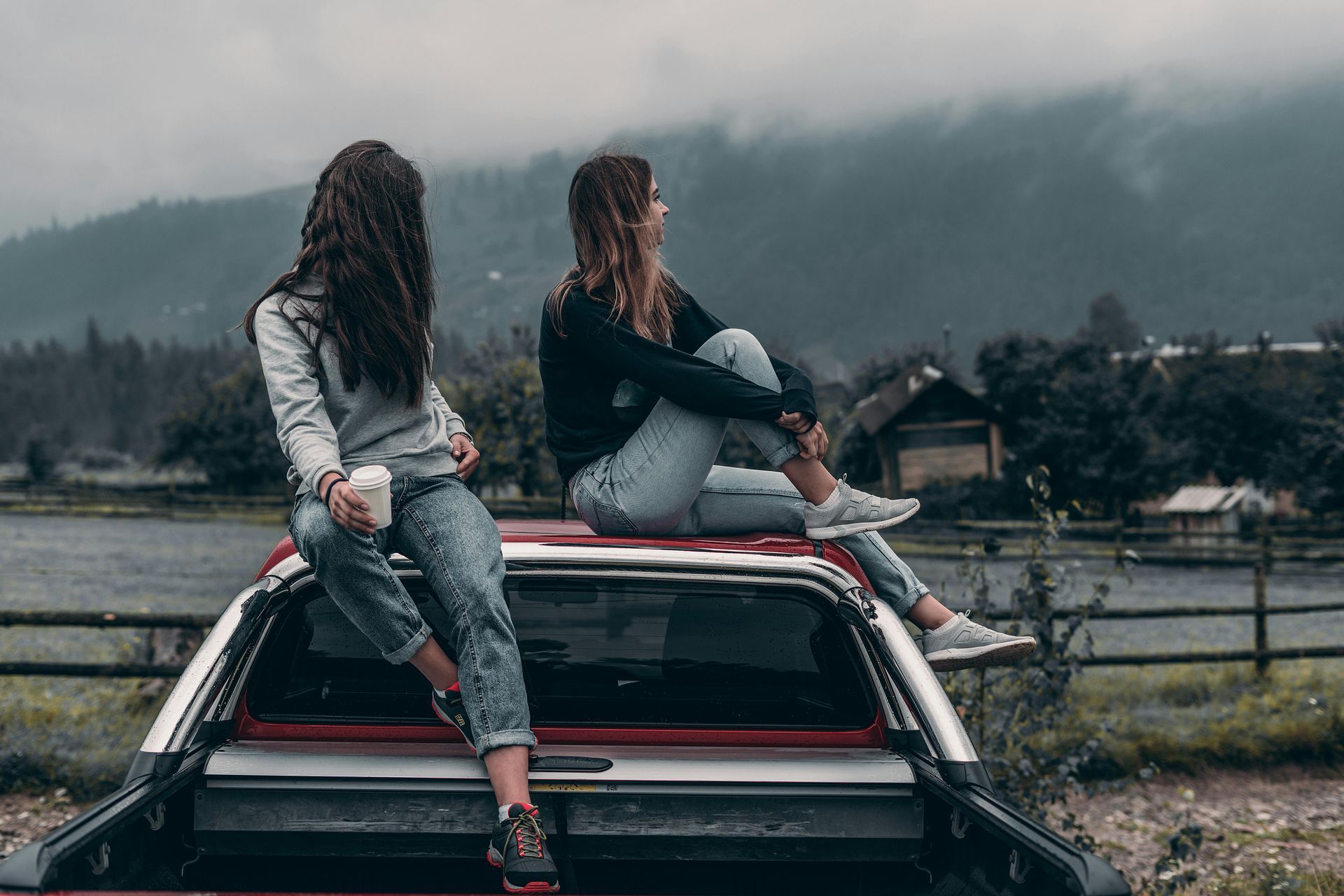 Back to simple life Two women are sitting on the back of a truck.