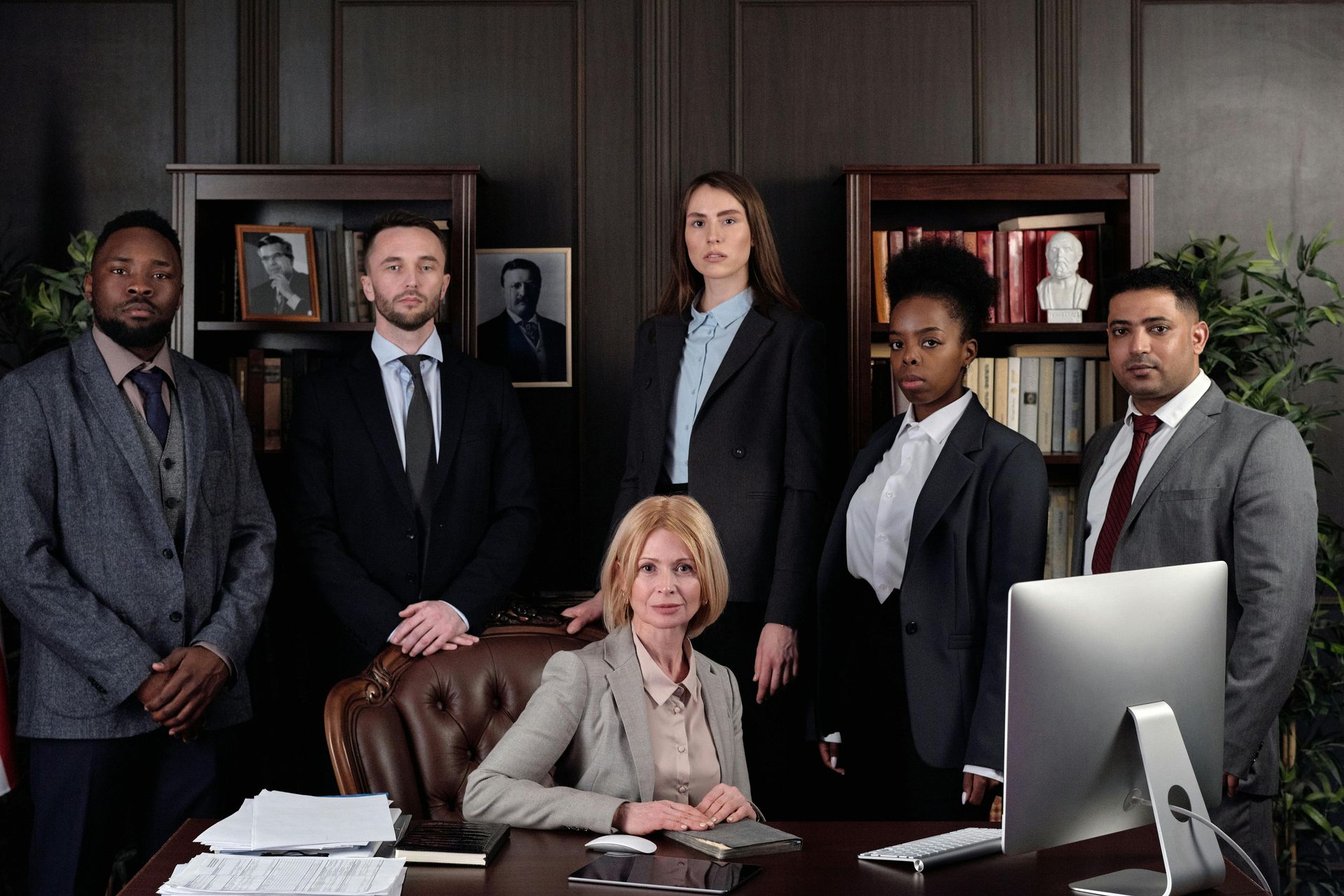 As 48 leis do poder: Edição concisa Group of people in suits standing and sitting in a law office, looking at the camera.