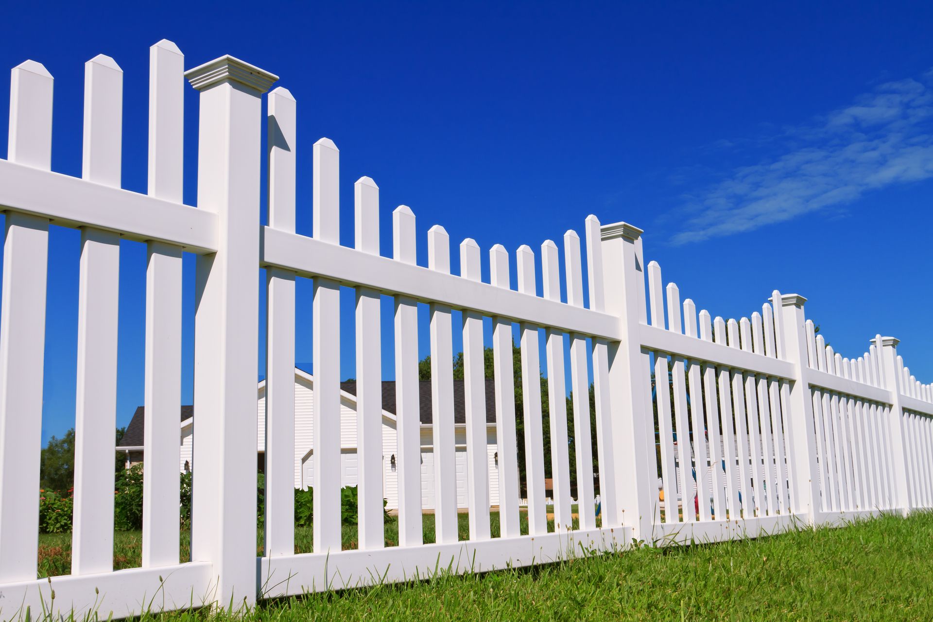 White vinyl privacy fence installed around a residential backyard