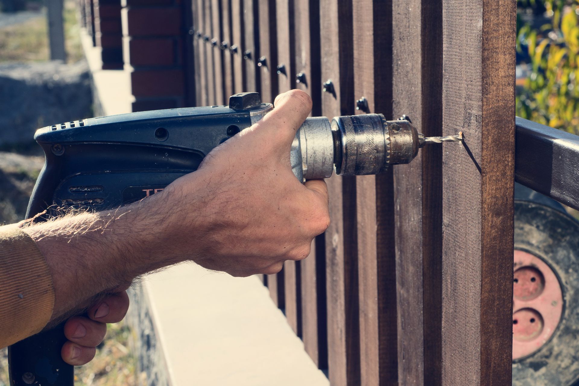A man is installing a wood fence. A man is installing a wood fence.