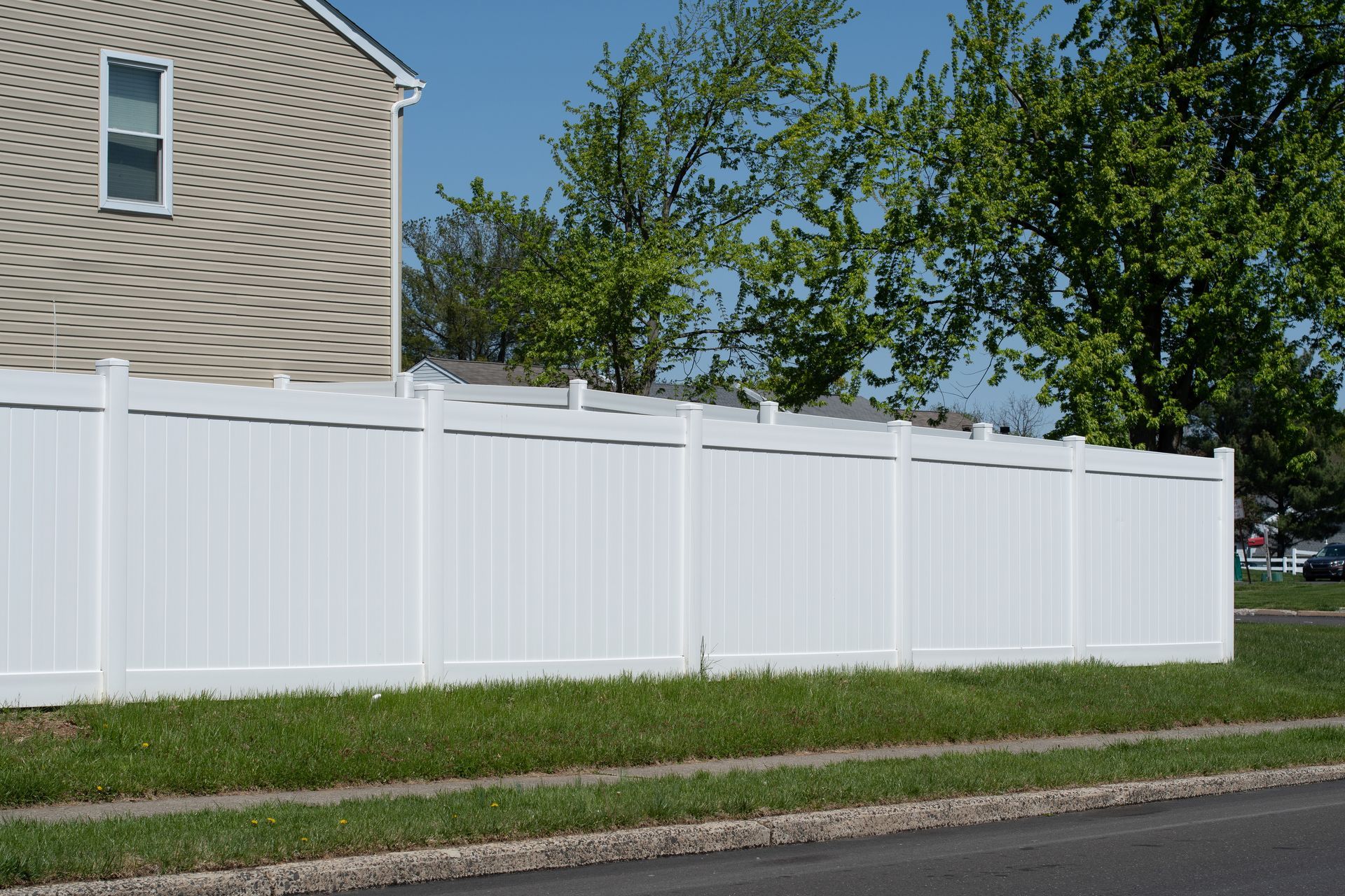 White vinyl privacy fence enclosing a residential property White vinyl privacy fence enclosing a residential property