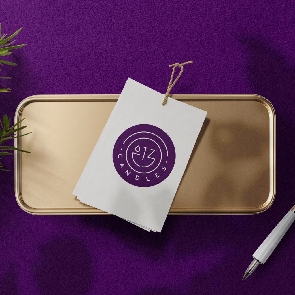 Purple branding mockup with a gold tray, hanging tag, and pen on a purple background