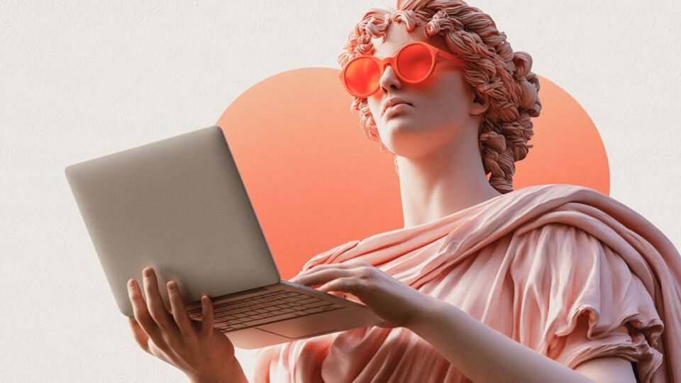 Person in red glasses using a laptop against a coral background
