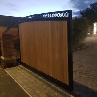 Bespoke metal framed timber sliding driveway gate — hardwood infill, steel frame, fabricated and installed by Nottingham Metalworks