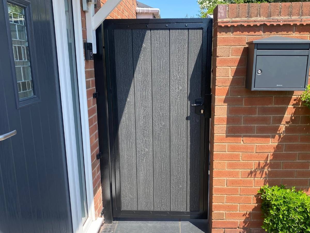 Metal framed composite driveway gate with fleur-de-lis top detail — grey composite infill, fabricated and installed in Nottingham