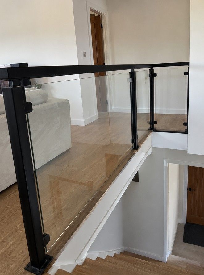 Steel and glass infill balustrade on an open-plan residential staircase, fabricated and installed by Nottingham Metalworks