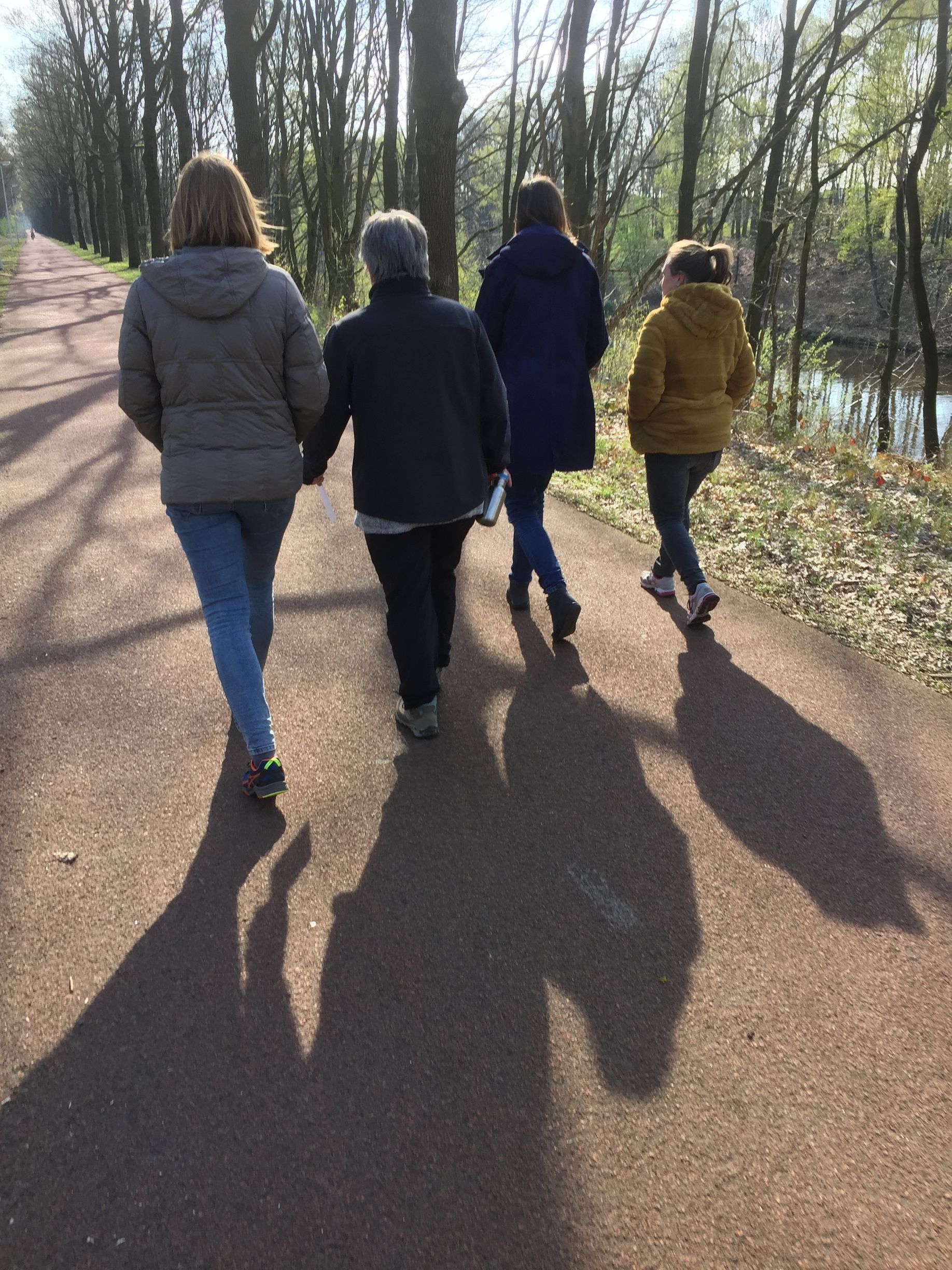 Vier mensen lopen over een pad 