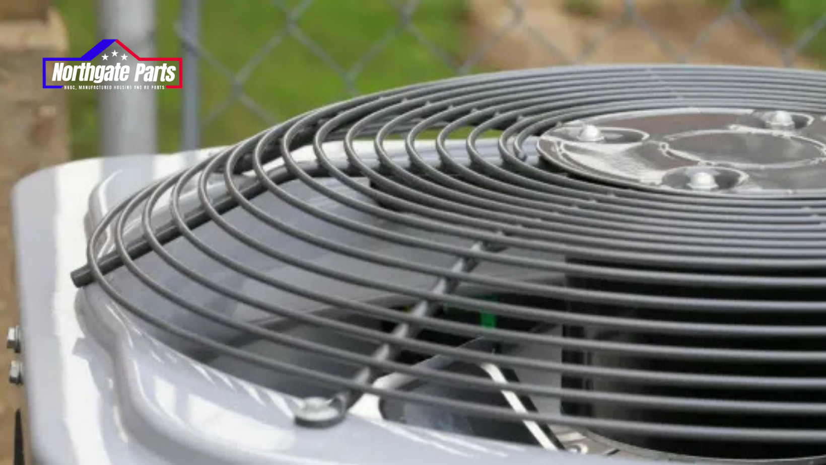 A close up of an air conditioner sitting next to a chain link fence.